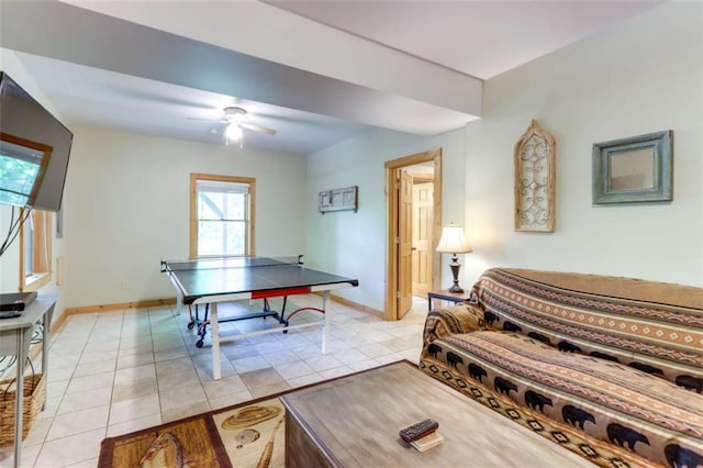 recreation room with light tile patterned flooring, a ceiling fan, and baseboards