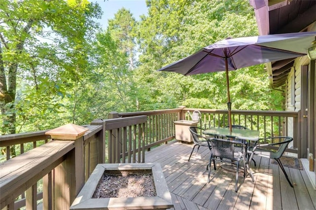 wooden deck featuring a fire pit and outdoor dining space