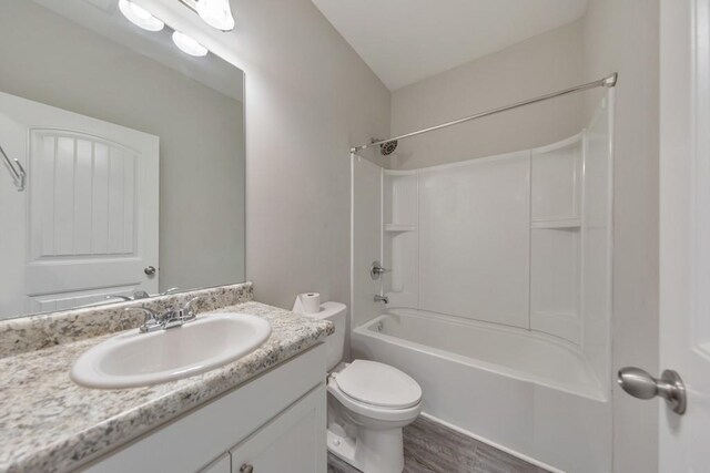 full bathroom featuring toilet, vanity, wood finished floors, and shower / tub combination