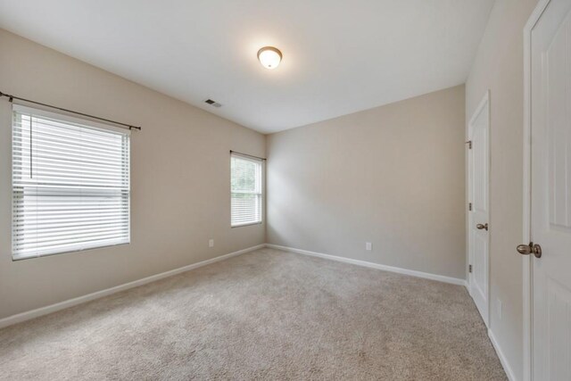 carpeted spare room with baseboards