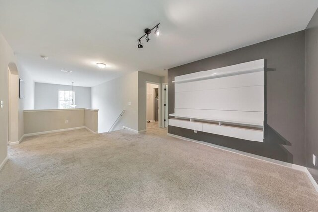 carpeted cinema room with baseboards and arched walkways