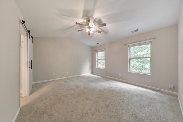 unfurnished room featuring ceiling fan, lofted ceiling, baseboards, and light colored carpet