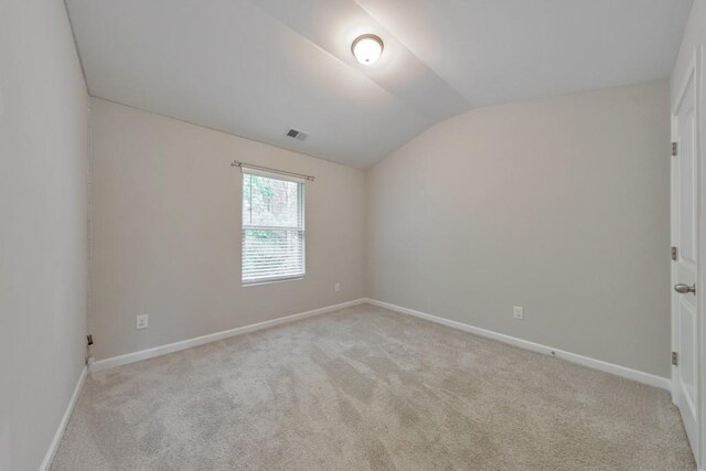 unfurnished room with lofted ceiling, light colored carpet, and baseboards