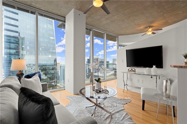 living room with ceiling fan, wood-type flooring, and floor to ceiling windows