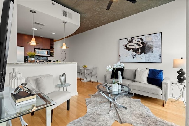 living room with ceiling fan and light hardwood / wood-style floors