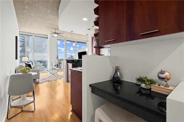 kitchen featuring ceiling fan, light hardwood / wood-style flooring, and floor to ceiling windows