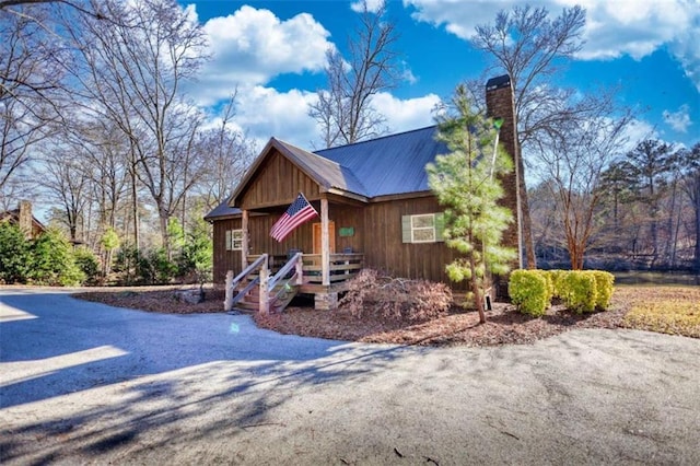 rustic home featuring metal roof and a chimney