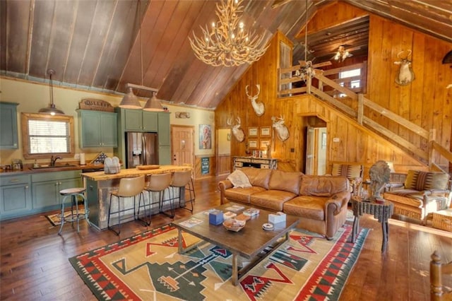 living area featuring wood ceiling, wood walls, high vaulted ceiling, hardwood / wood-style floors, and ceiling fan with notable chandelier