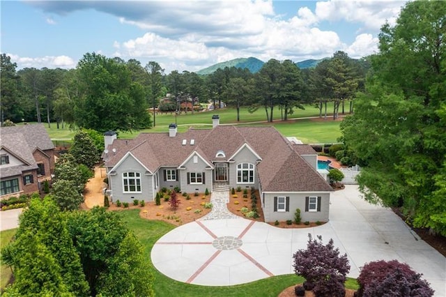 view of front of property featuring a pool, a front lawn, and a mountain view