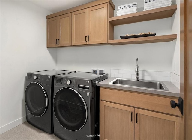 laundry area featuring cabinets, sink, and independent washer and dryer