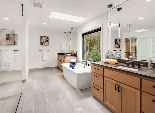 bathroom featuring vanity, shower with separate bathtub, a skylight, and tile patterned flooring