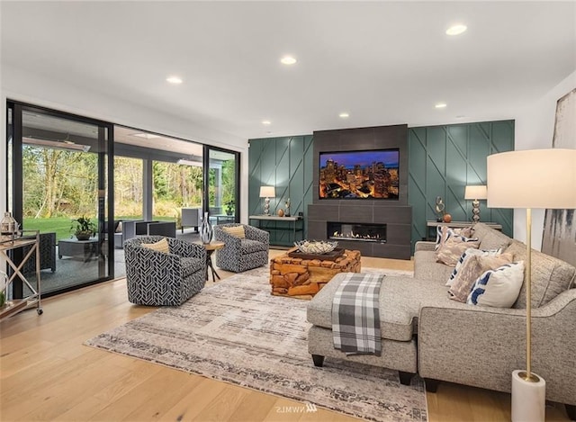 living room featuring a tiled fireplace and light hardwood / wood-style flooring