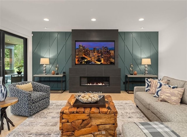 cinema room featuring hardwood / wood-style floors and a tile fireplace