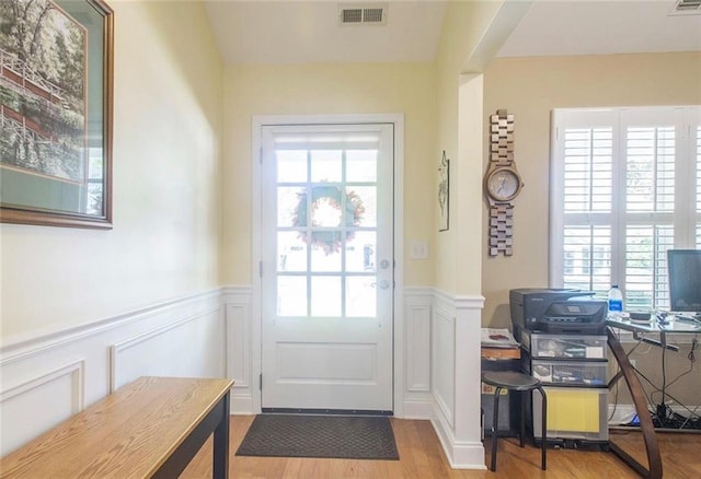 doorway with light hardwood / wood-style flooring and a wealth of natural light