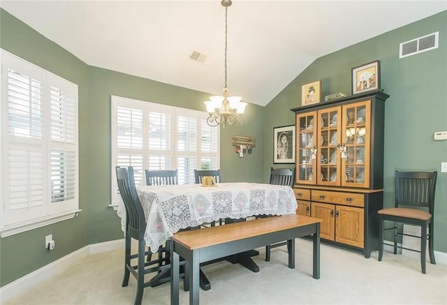 carpeted dining space featuring a chandelier and vaulted ceiling