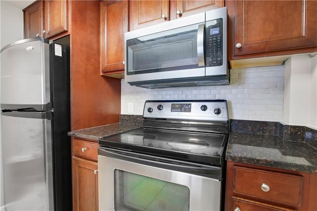 kitchen featuring dark stone countertops, stainless steel appliances, and decorative backsplash