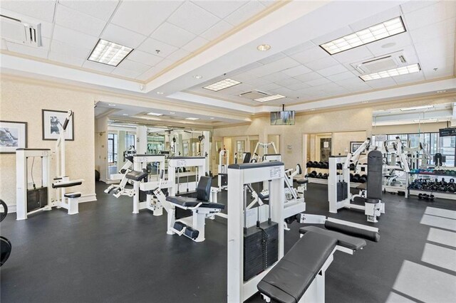 exercise room with a healthy amount of sunlight and a drop ceiling