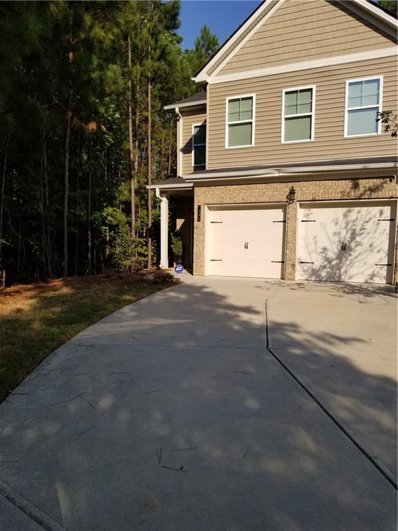 7298 Rockhouse Rd Unit 5, Austell, GA 30168 - view of front of house featuring an attached garage, driveway, and brick siding