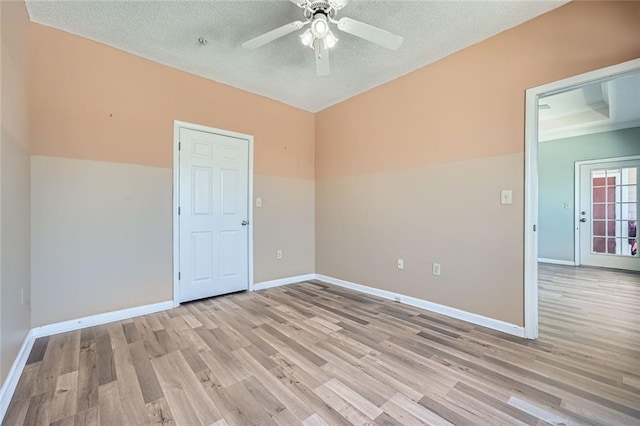 spare room featuring ceiling fan, a textured ceiling, and light hardwood / wood-style floors