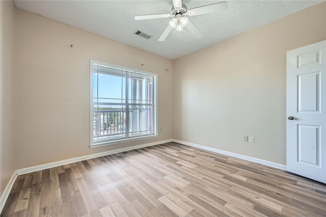 empty room featuring ceiling fan, light hardwood / wood-style flooring, and a textured ceiling