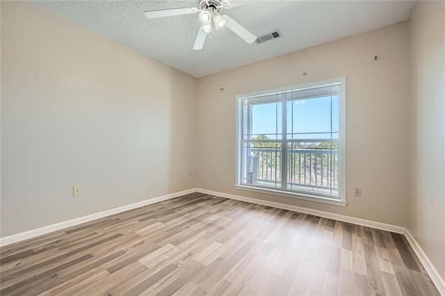 spare room featuring ceiling fan, a textured ceiling, and light hardwood / wood-style flooring