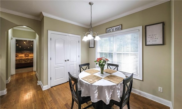 dining room featuring ornamental molding, an inviting chandelier, and dark hardwood / wood-style floors