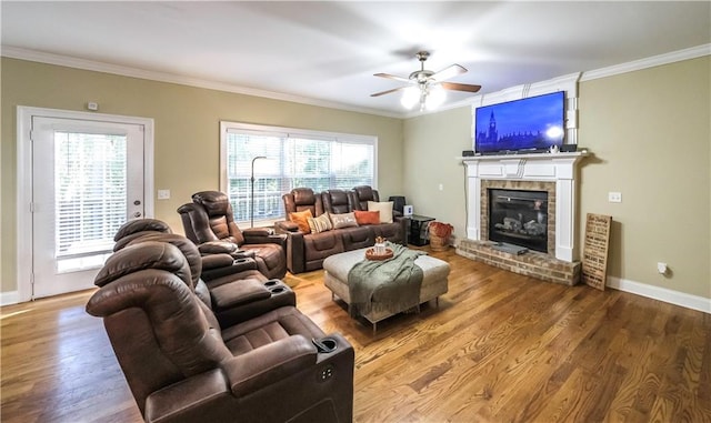 living room featuring crown molding, hardwood / wood-style flooring, plenty of natural light, and a fireplace