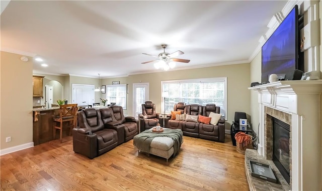 living room with sink, crown molding, light hardwood / wood-style flooring, and ceiling fan with notable chandelier