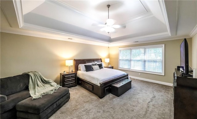 carpeted bedroom with ornamental molding, a tray ceiling, and ceiling fan