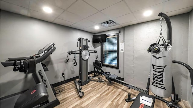 exercise room featuring a drop ceiling and wood-type flooring