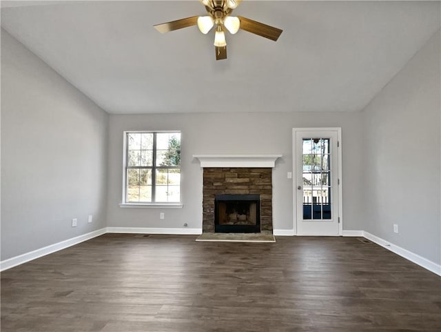 unfurnished living room featuring dark wood-type flooring, plenty of natural light, ceiling fan, and vaulted ceiling