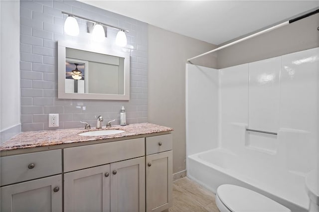 3595 S St NW, Duluth, GA 30096 - full bathroom featuring toilet, decorative backsplash, vanity, washtub / shower combination, and baseboards
