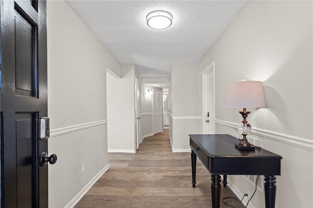 3595 S St NW, Duluth, GA 30096 - hallway featuring a textured ceiling, wood finished floors, and baseboards