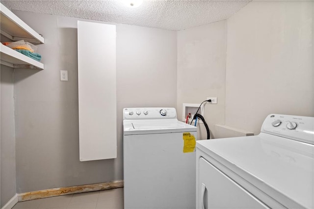 3595 S St NW, Duluth, GA 30096 - laundry room featuring washing machine and clothes dryer, a textured ceiling, and baseboards