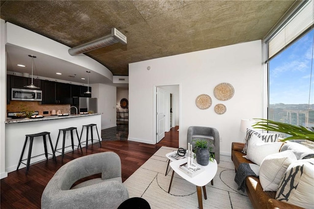 living room with baseboards and dark wood-type flooring