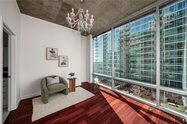 living area with floor to ceiling windows, baseboards, dark wood-style flooring, and a chandelier