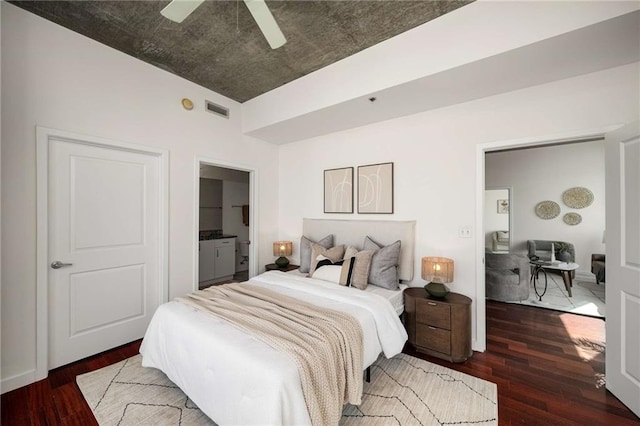 bedroom with connected bathroom, visible vents, wood finished floors, and a ceiling fan