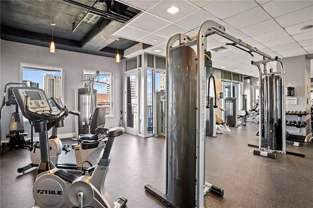 gym with baseboards and a paneled ceiling