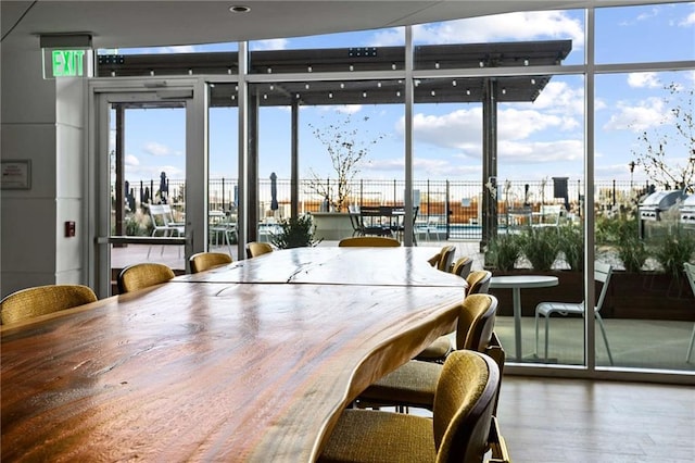 unfurnished dining area featuring floor to ceiling windows, plenty of natural light, and wood finished floors