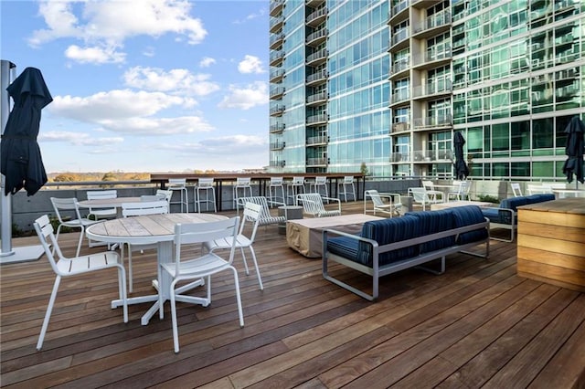 wooden terrace featuring outdoor dining area and an outdoor hangout area