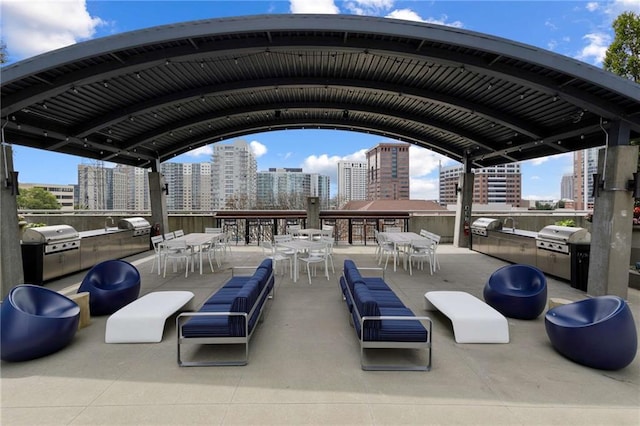 view of patio / terrace featuring outdoor dining space, exterior kitchen, a view of city, and area for grilling