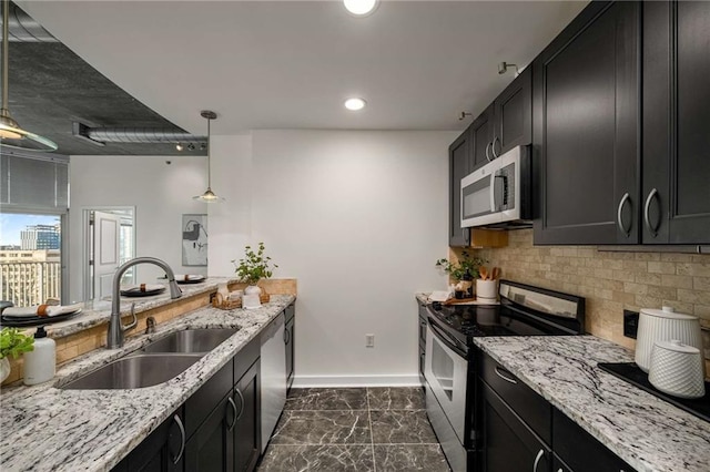 kitchen featuring a sink, appliances with stainless steel finishes, decorative backsplash, and dark cabinets