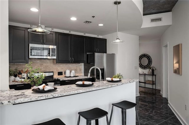 kitchen with visible vents, marble finish floor, backsplash, appliances with stainless steel finishes, and dark cabinets