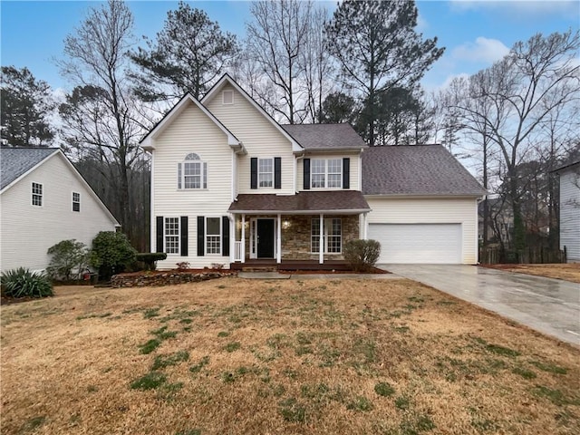 view of front of home with a garage, driveway, stone siding, a porch, and a front yard