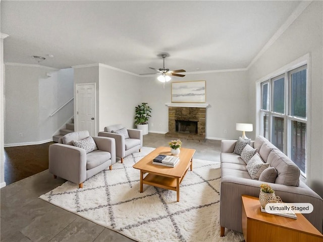 living area featuring stairs, ceiling fan, a stone fireplace, and crown molding