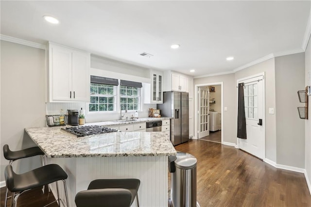 kitchen featuring white cabinetry, sink, dark wood-type flooring, stainless steel appliances, and kitchen peninsula