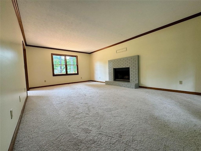 unfurnished living room featuring ornamental molding, carpet floors, a textured ceiling, baseboards, and a brick fireplace