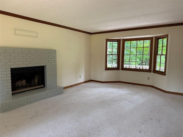 unfurnished living room featuring light colored carpet, ornamental molding, baseboards, and a brick fireplace