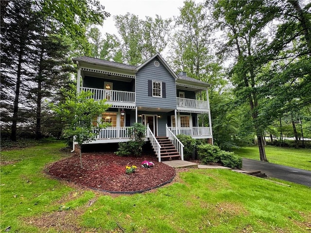 view of front of home featuring a balcony, a porch, a front lawn, and driveway