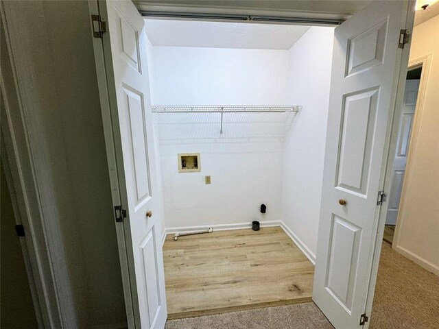 washroom with washer hookup, baseboards, and light wood-type flooring